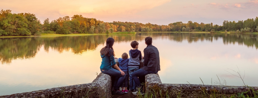 Family in front of a pond in Dombes